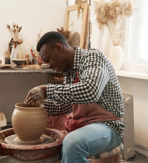 cheerful-man-working-on-new-clay-vessel-resize